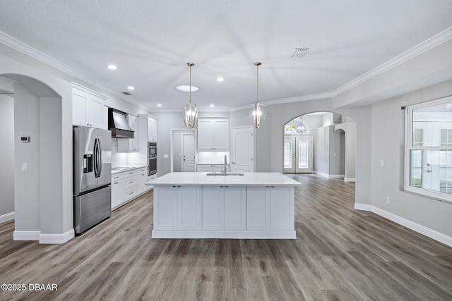 7 Traceway Ct, Ormond Beach, FL 32174 - kitchen featuring appliances with stainless steel finishes, custom exhaust hood, arched walkways, light countertops, and white cabinets