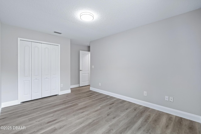 7 Traceway Ct, Ormond Beach, FL 32174 - unfurnished bedroom featuring light wood-style floors, a closet, and a textured ceiling