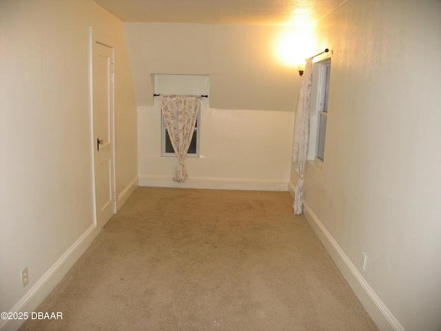 hallway featuring carpet floors and baseboards