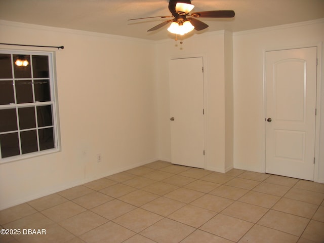 empty room featuring ceiling fan and crown molding