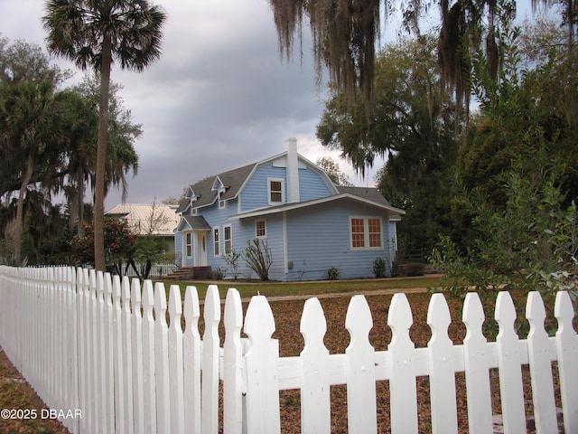 view of front of property featuring a fenced front yard and a gambrel roof