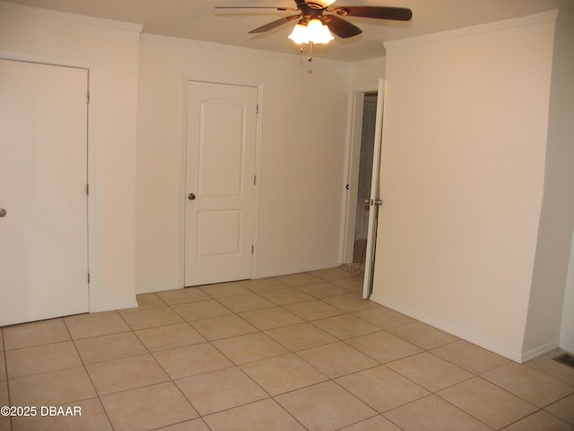 unfurnished room featuring light tile patterned floors, crown molding, and ceiling fan