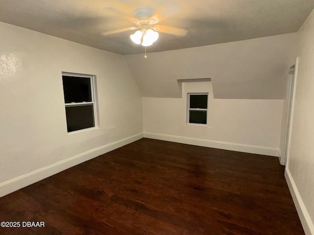 bonus room featuring vaulted ceiling, dark wood finished floors, and baseboards