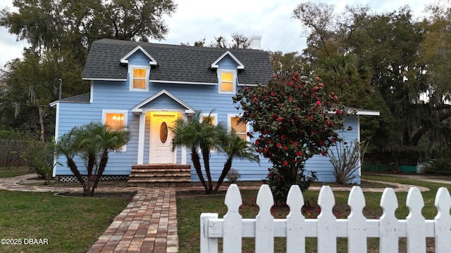 traditional-style house with a shingled roof, entry steps, fence, and a chimney