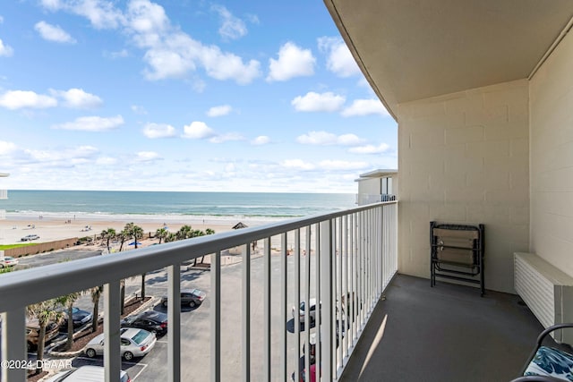 balcony with a water view, a beach view, and radiator