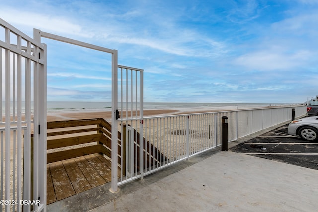 view of gate with a water view and a view of the beach