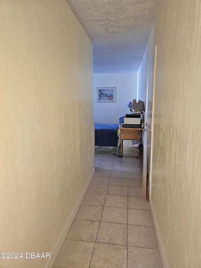 1233 S Atlantic Ave Unit 3310, Daytona Beach, FL 32118 - hall featuring light tile patterned floors, a textured ceiling, and baseboards