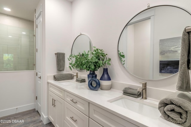 bathroom with vanity, wood-type flooring, and tiled shower