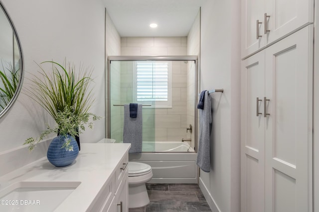 full bathroom with vanity, shower / bath combination with glass door, and toilet