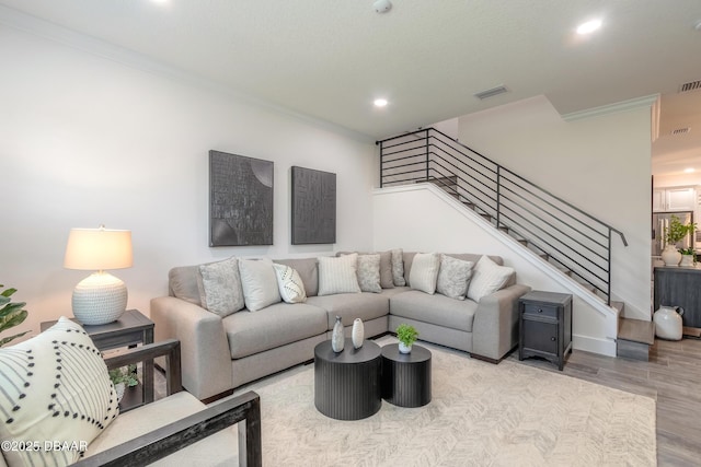 living room featuring ornamental molding and light hardwood / wood-style floors