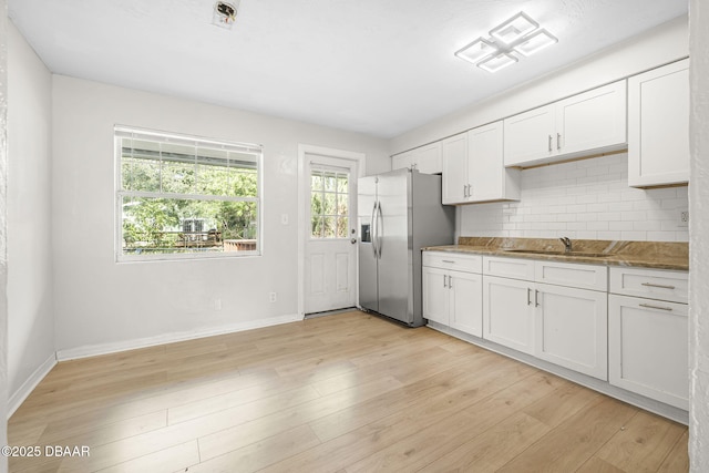 656 Winchester St, Daytona Beach, FL 32114 - kitchen with white cabinets, a sink, stainless steel fridge with ice dispenser, baseboards, and tasteful backsplash