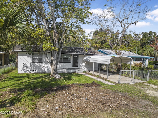 656 Winchester St, Daytona Beach, FL 32114 - back of house with a yard, fence, and a carport