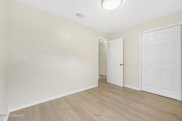 656 Winchester St, Daytona Beach, FL 32114 - unfurnished bedroom with light wood-style floors, baseboards, a closet, and visible vents