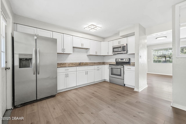 656 Winchester St, Daytona Beach, FL 32114 - kitchen with a sink, baseboards, white cabinets, and stainless steel appliances