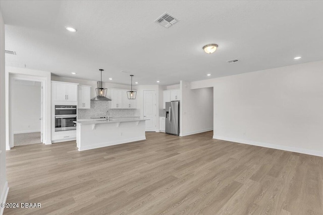 kitchen featuring white cabinetry, light hardwood / wood-style floors, decorative light fixtures, a kitchen island with sink, and appliances with stainless steel finishes