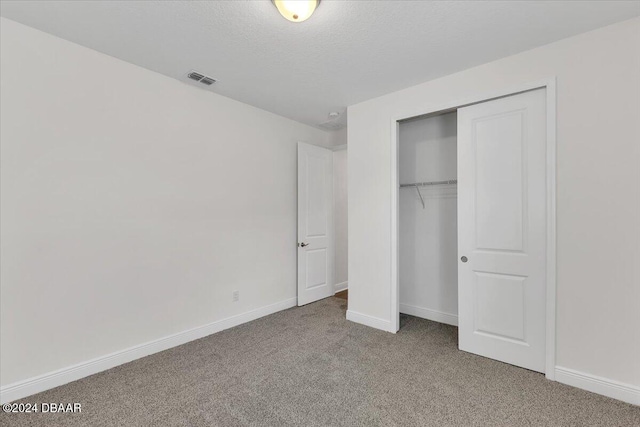 unfurnished bedroom featuring carpet flooring, a closet, and a textured ceiling