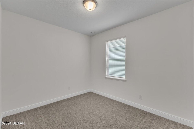 carpeted spare room with a textured ceiling