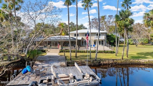 dock area with a water view, a balcony, and a yard