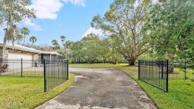 view of gate featuring a garage and a yard