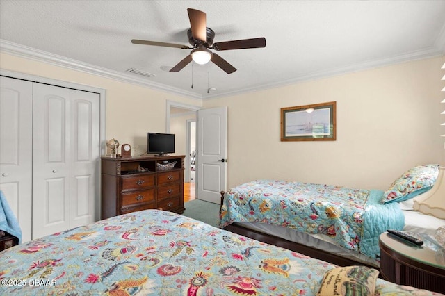 bedroom featuring ceiling fan, ornamental molding, a closet, and a textured ceiling