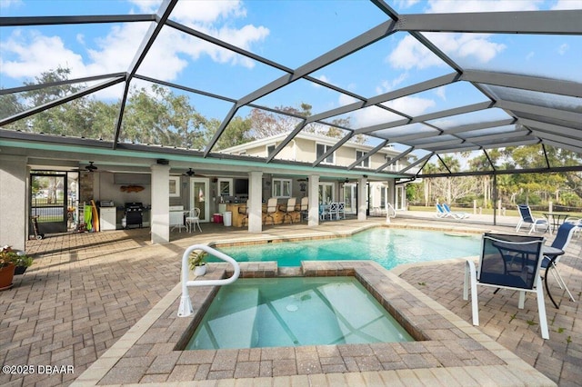 view of pool with an in ground hot tub, exterior bar, a patio area, and a lanai