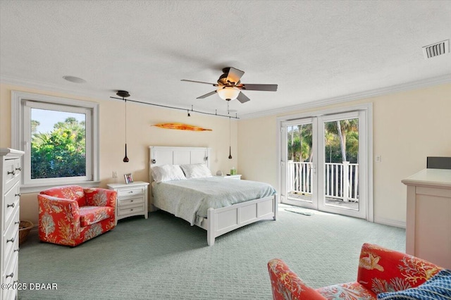 carpeted bedroom with ornamental molding, access to outside, a textured ceiling, and french doors