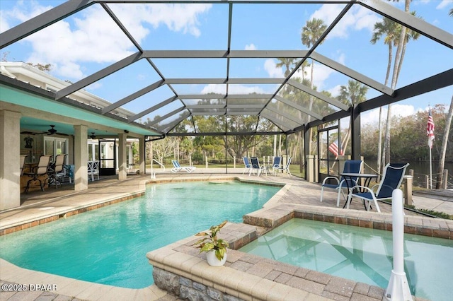 view of pool with a patio, an in ground hot tub, ceiling fan, and glass enclosure