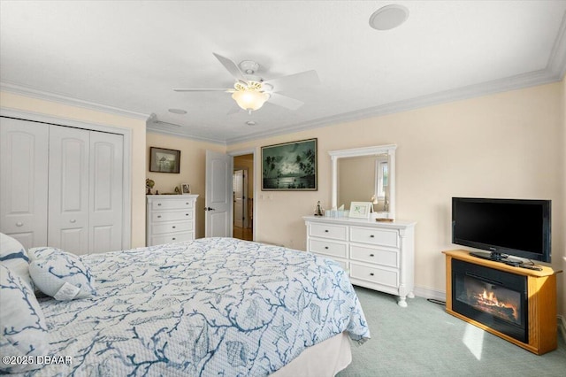 bedroom with ornamental molding, carpet floors, ceiling fan, and a closet