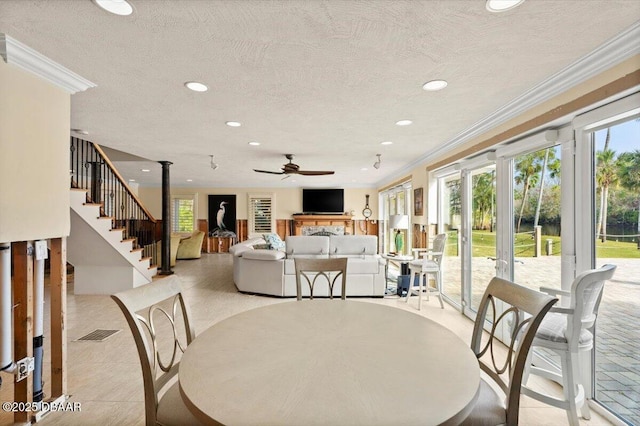 dining room with crown molding, a wealth of natural light, and a textured ceiling