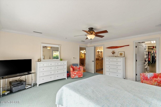 bedroom with ensuite bath, ceiling fan, carpet, ornamental molding, and a spacious closet