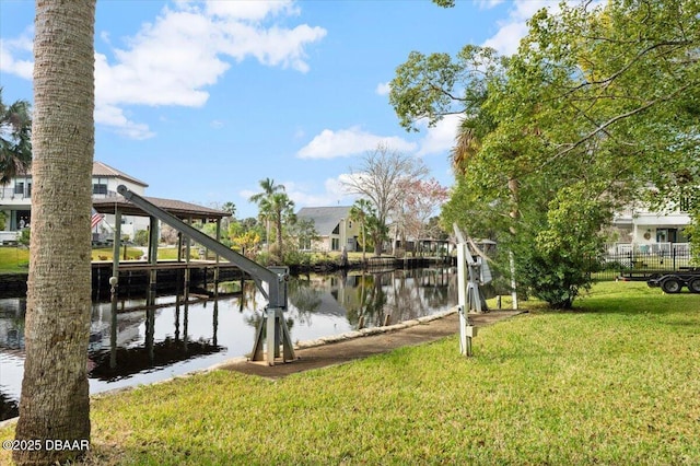 dock area with a water view and a yard