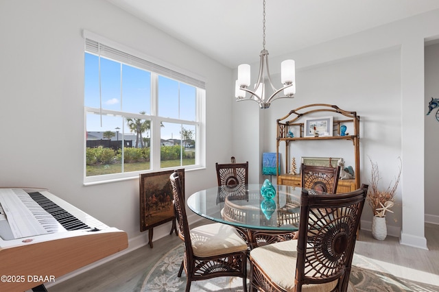 dining room with baseboards, a chandelier, and wood finished floors