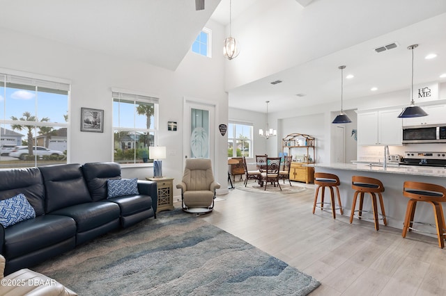 living area with a chandelier, recessed lighting, visible vents, and light wood-style flooring