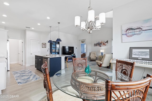 dining area featuring lofted ceiling, recessed lighting, a notable chandelier, light wood-style floors, and baseboards