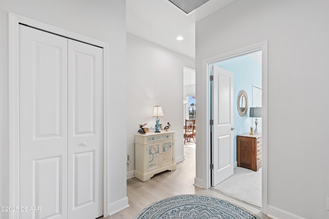 hallway with baseboards, visible vents, light wood-style flooring, and recessed lighting