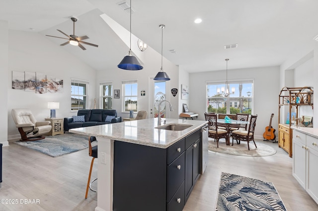 kitchen with stainless steel dishwasher, dark cabinets, visible vents, and a sink