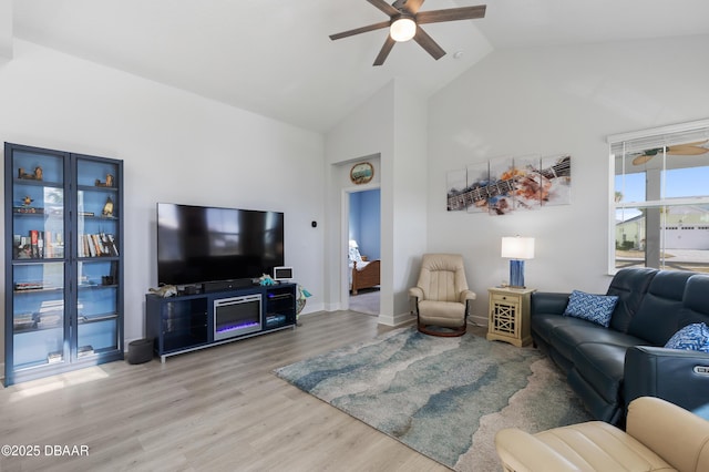 living room featuring high vaulted ceiling, baseboards, a ceiling fan, and wood finished floors