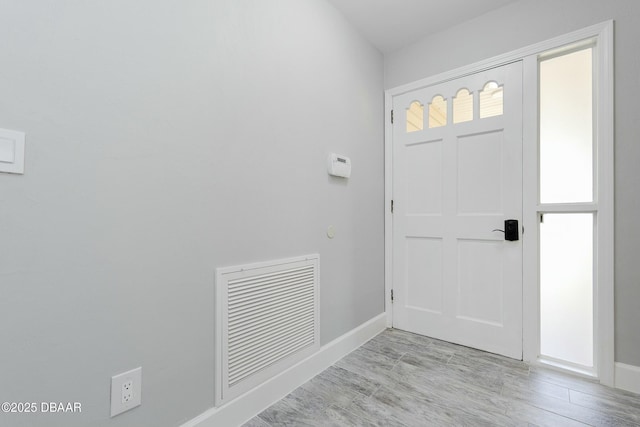 entryway featuring baseboards, visible vents, and wood finished floors