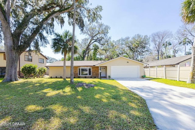 view of front facade with concrete driveway, an attached garage, fence, and a front yard