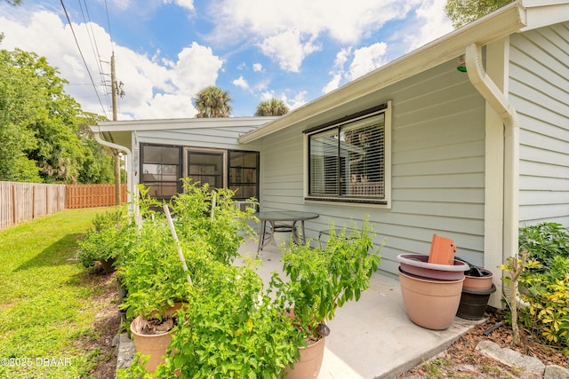 property entrance featuring a lawn and a patio