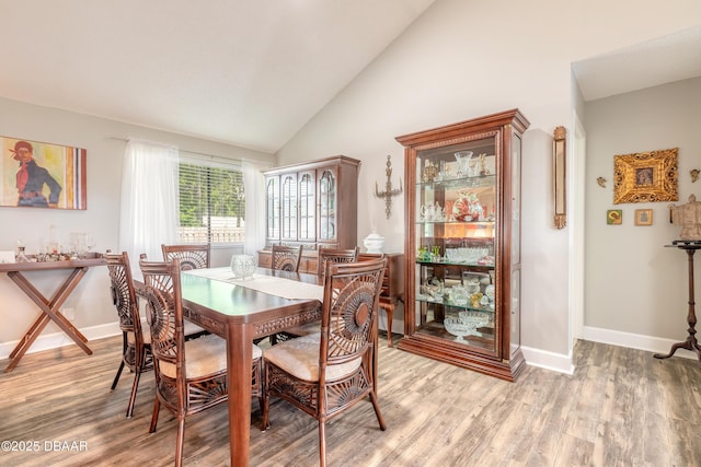 dining room featuring hardwood / wood-style floors and high vaulted ceiling