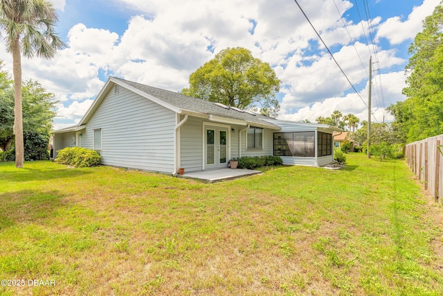 back of house featuring a yard, a sunroom, french doors, and a patio