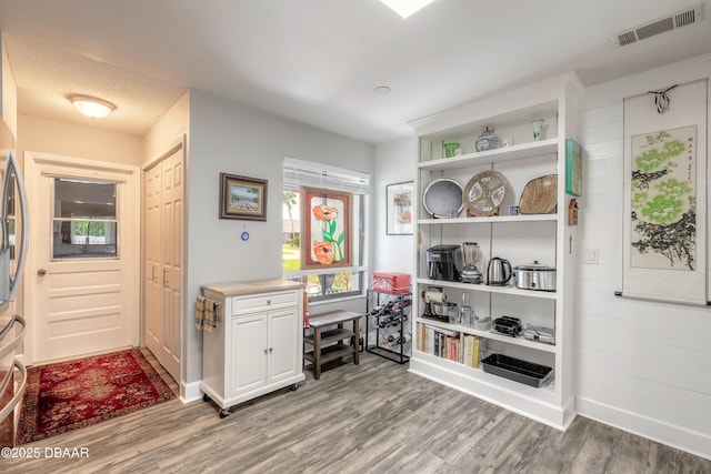 interior space with a textured ceiling and hardwood / wood-style floors