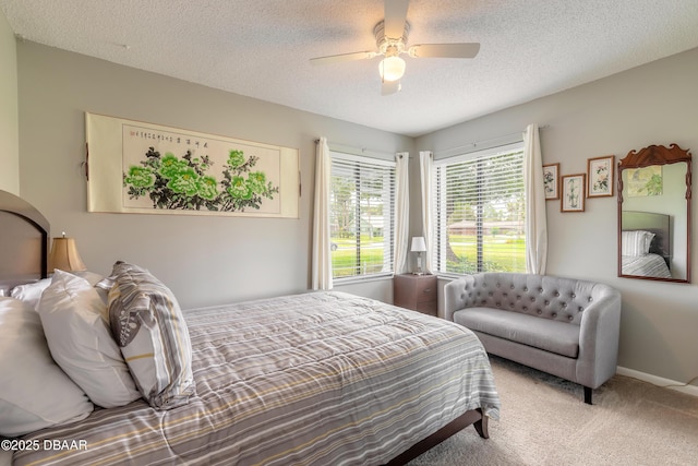 carpeted bedroom featuring ceiling fan and a textured ceiling