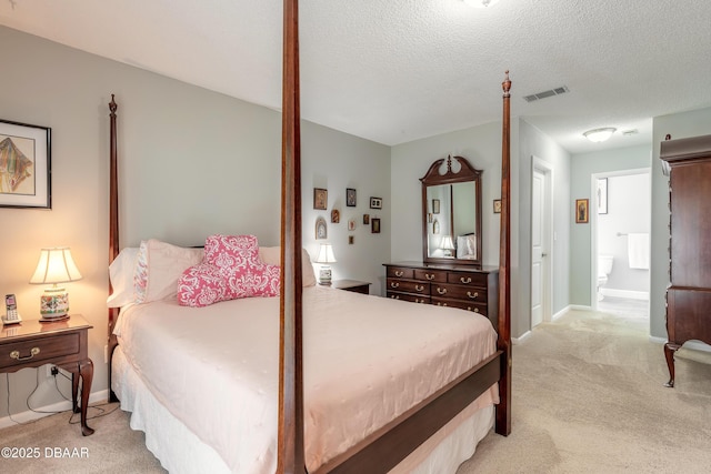 carpeted bedroom featuring connected bathroom and a textured ceiling