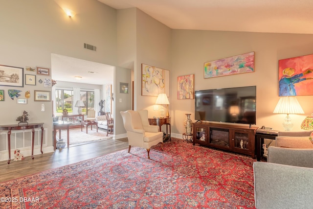 living room with hardwood / wood-style flooring and high vaulted ceiling