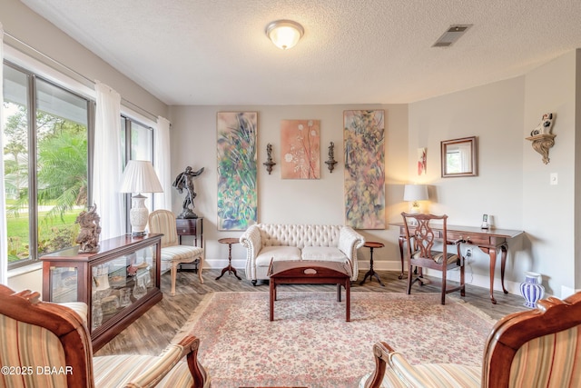 living room featuring light hardwood / wood-style floors and a textured ceiling