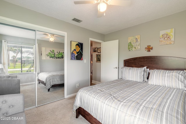 carpeted bedroom featuring ceiling fan, a textured ceiling, and a closet