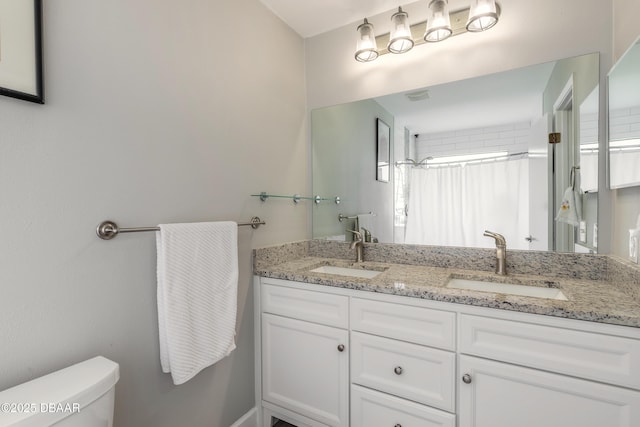 bathroom with toilet, vanity, and a shower with shower curtain