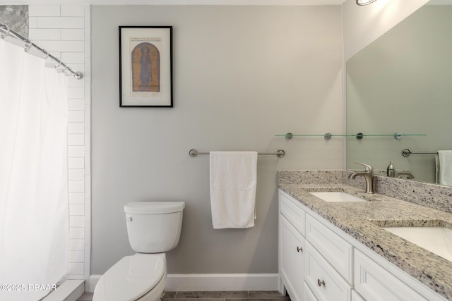 bathroom featuring toilet, vanity, and walk in shower